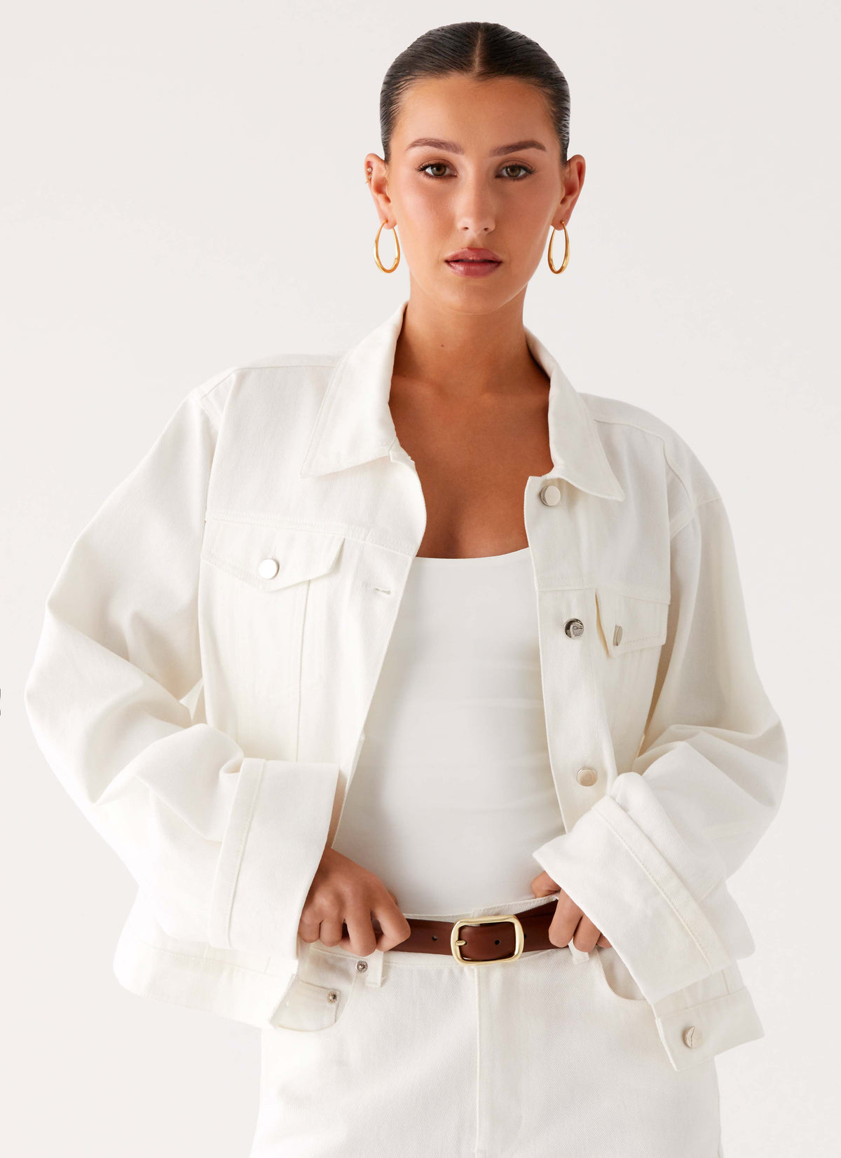 Women's oversized white denim jacket with shirt collar, chest pockets and snap fastenings