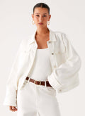 Women's oversized white denim jacket with shirt collar, chest pockets and snap fastenings