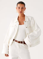 Women's oversized white denim jacket with shirt collar, chest pockets and snap fastenings