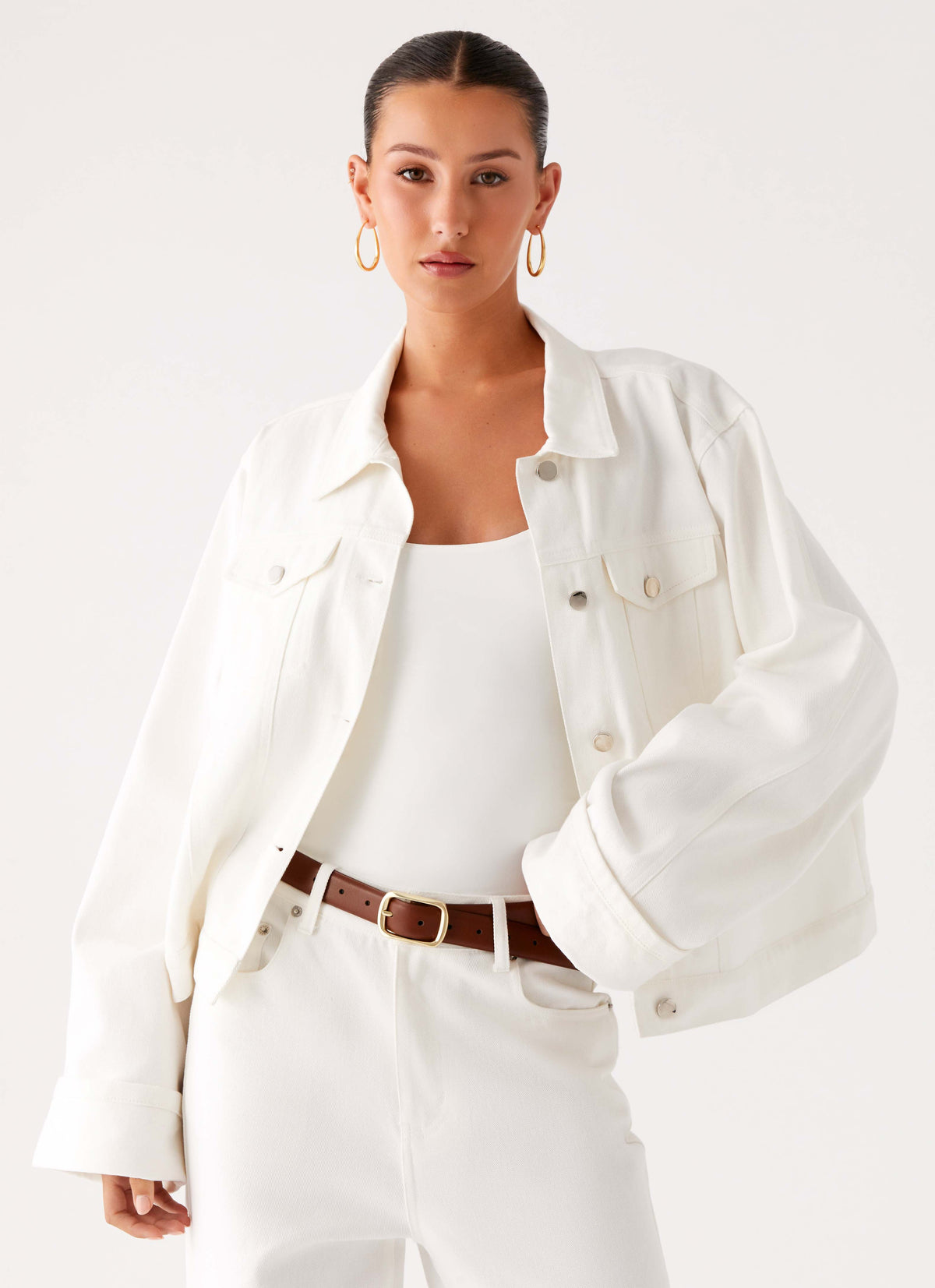 Women's oversized white denim jacket with shirt collar, chest pockets and snap fastenings