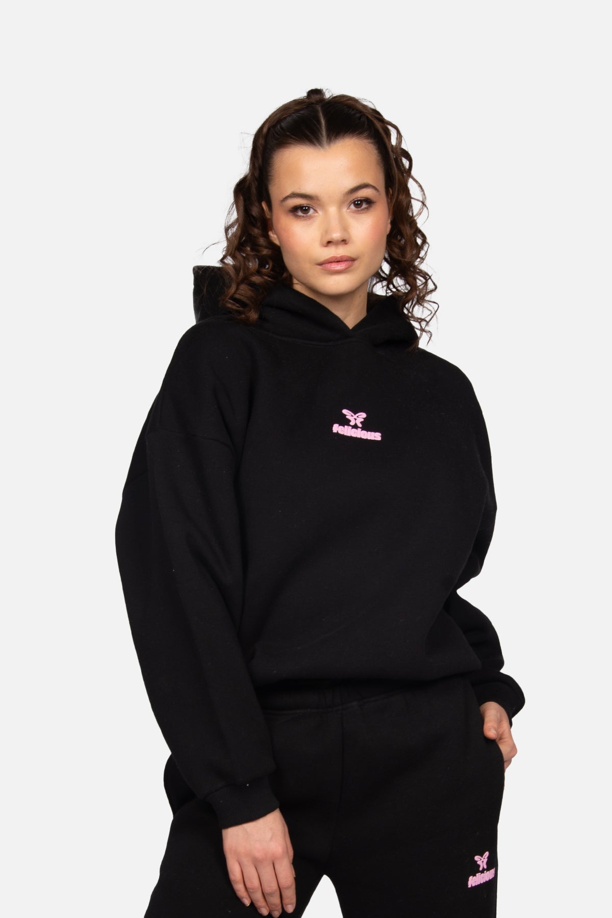 Women's black cropped hoodie with hood and pink chest logo