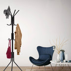Black freestanding coat rack stand with multiple curved hooks and three-legged base