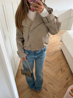 Women's beige cropped double-breasted trench jacket with long sleeves and adjustable cuffs