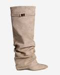 Women's beige slouchy knee-high boots with pointed toes, low heels and buckle straps
