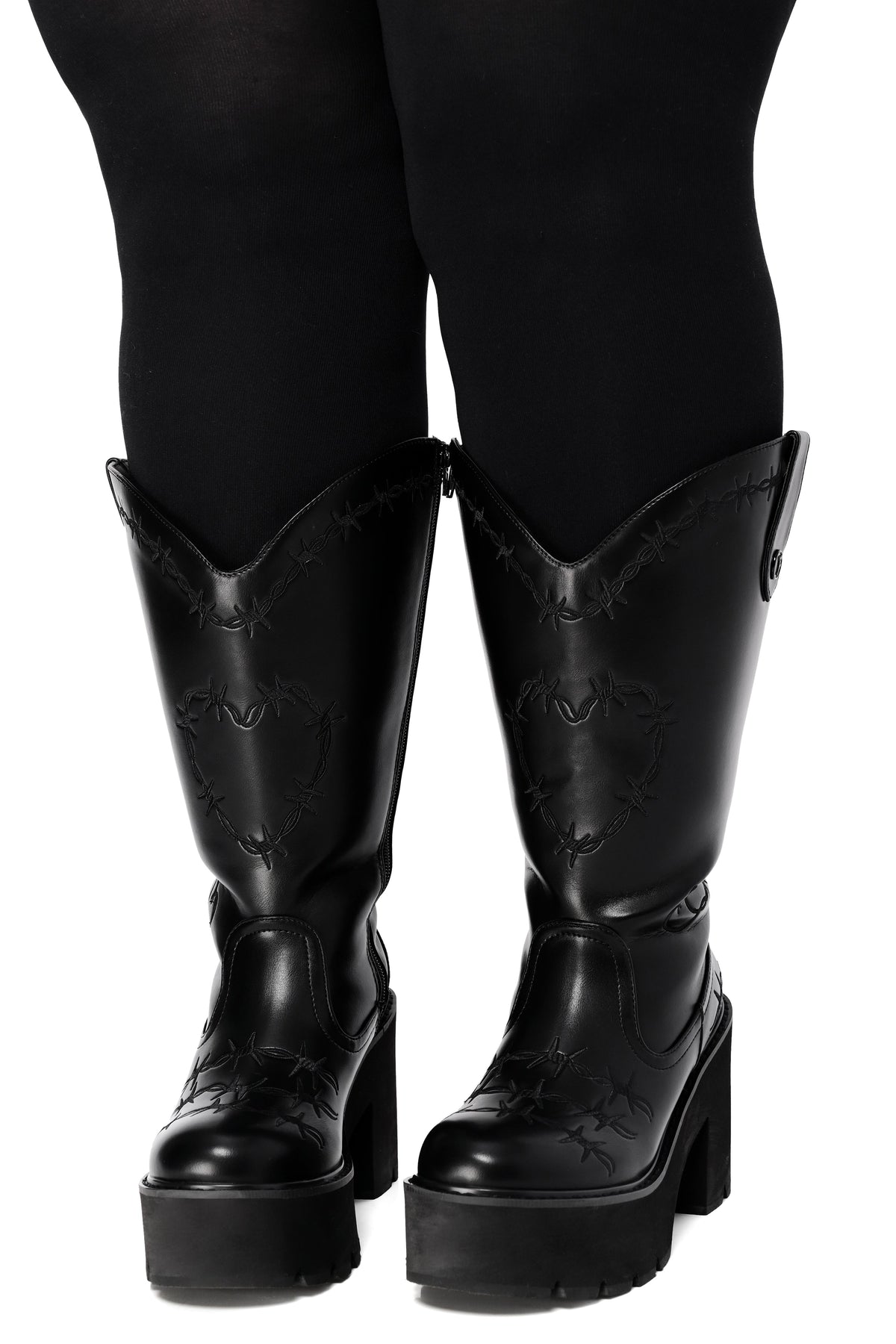 Black platform cowboy boots with barbed wire stitching and buckle straps