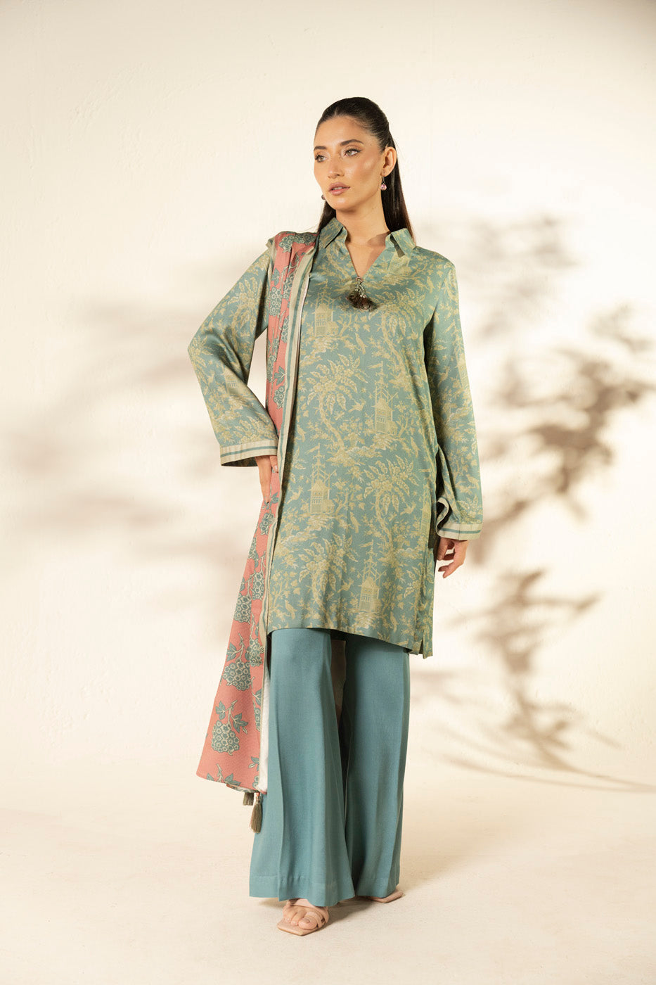 Woman wearing a blue printed longline shirt with collared V-neck and pink patterned dupatta