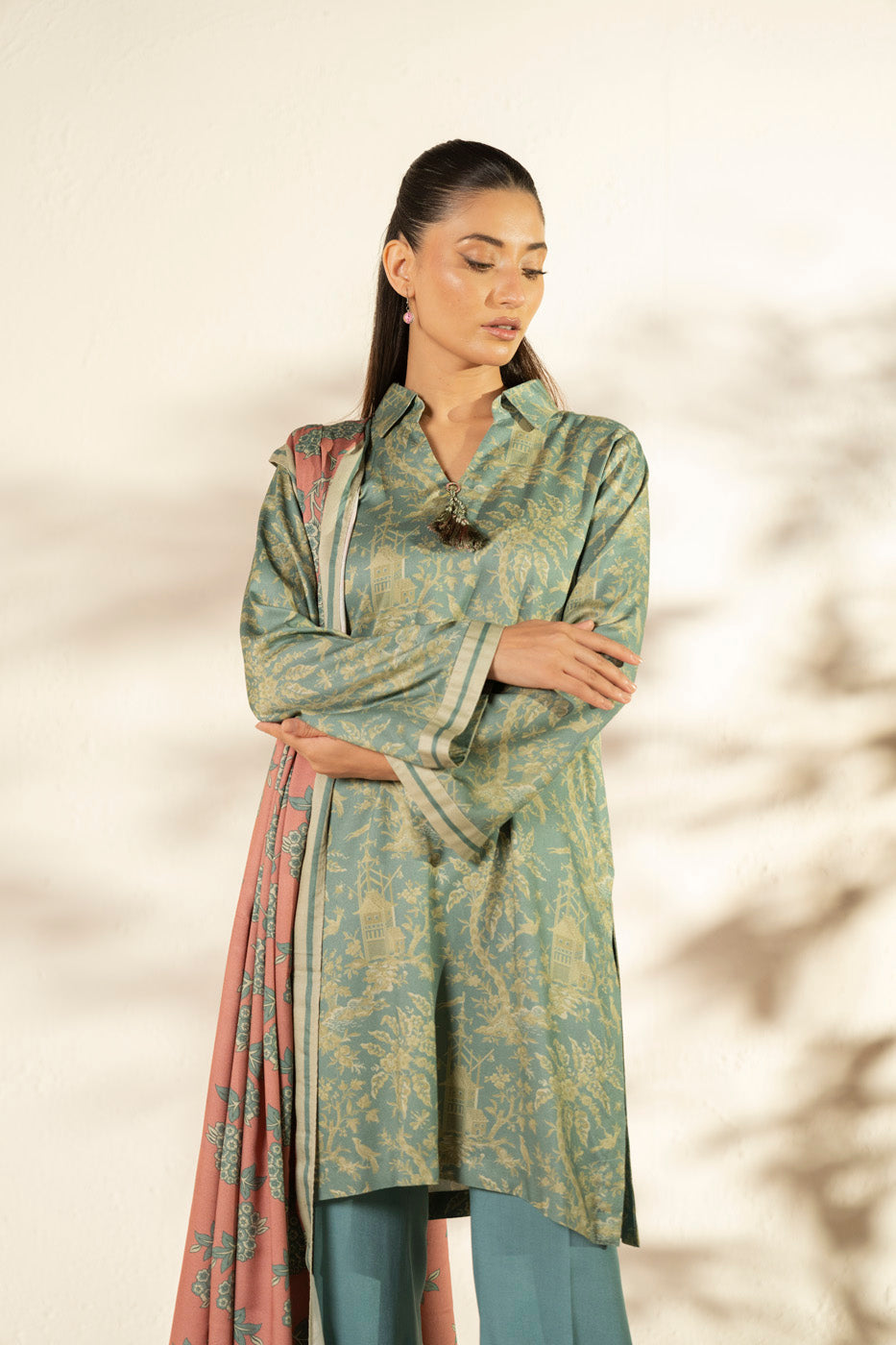 Woman wearing a blue printed longline shirt with collared V-neck and pink patterned dupatta