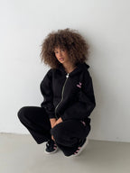 Women's black zip-up hoodie with hood, pink logo and front pocket