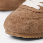 Women's plain low-top lace-up trainers with textured panels and flat soles
