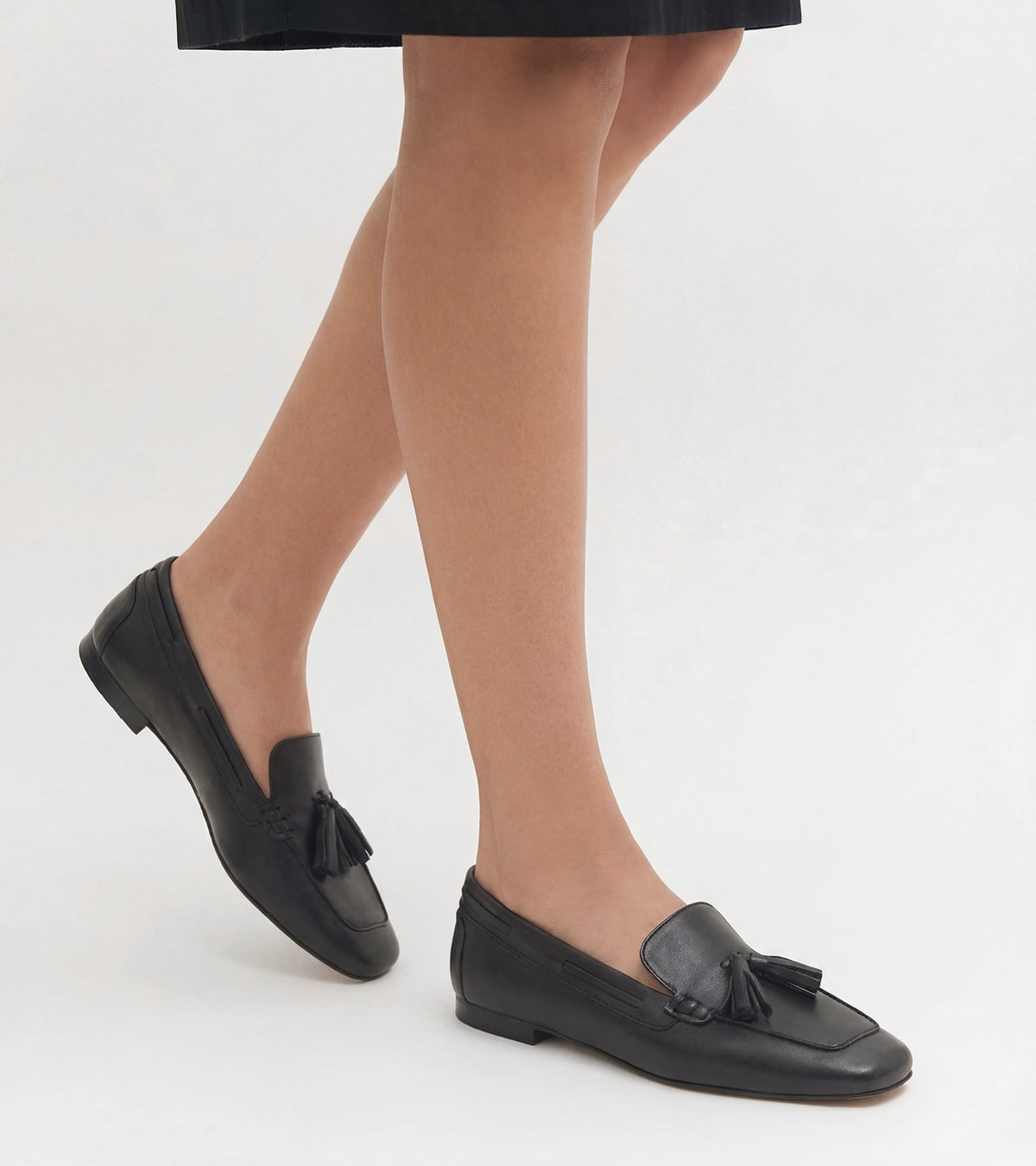 Women's black slip-on loafers with tassel detailing and low heels