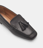 Women's black slip-on loafers with tassel detailing and low heels