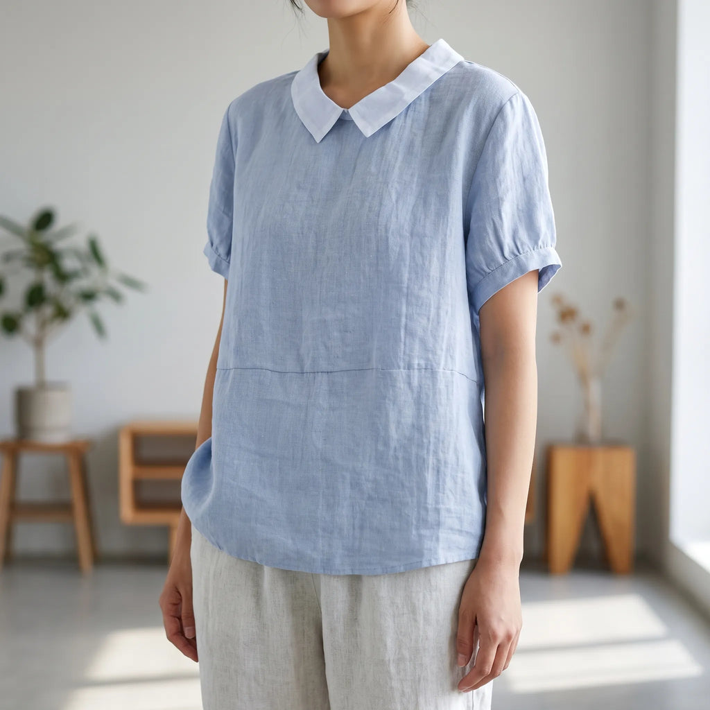 Women's light blue short-sleeved blouse with contrasting white rounded collar and curved hem