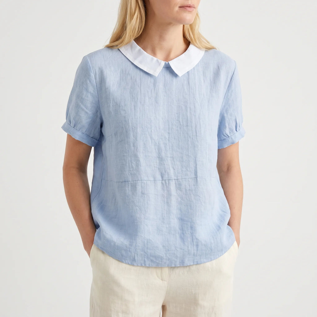 Women's light blue short-sleeved blouse with contrasting white rounded collar and curved hem