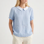 Women's light blue short-sleeved blouse with contrasting white rounded collar and curved hem