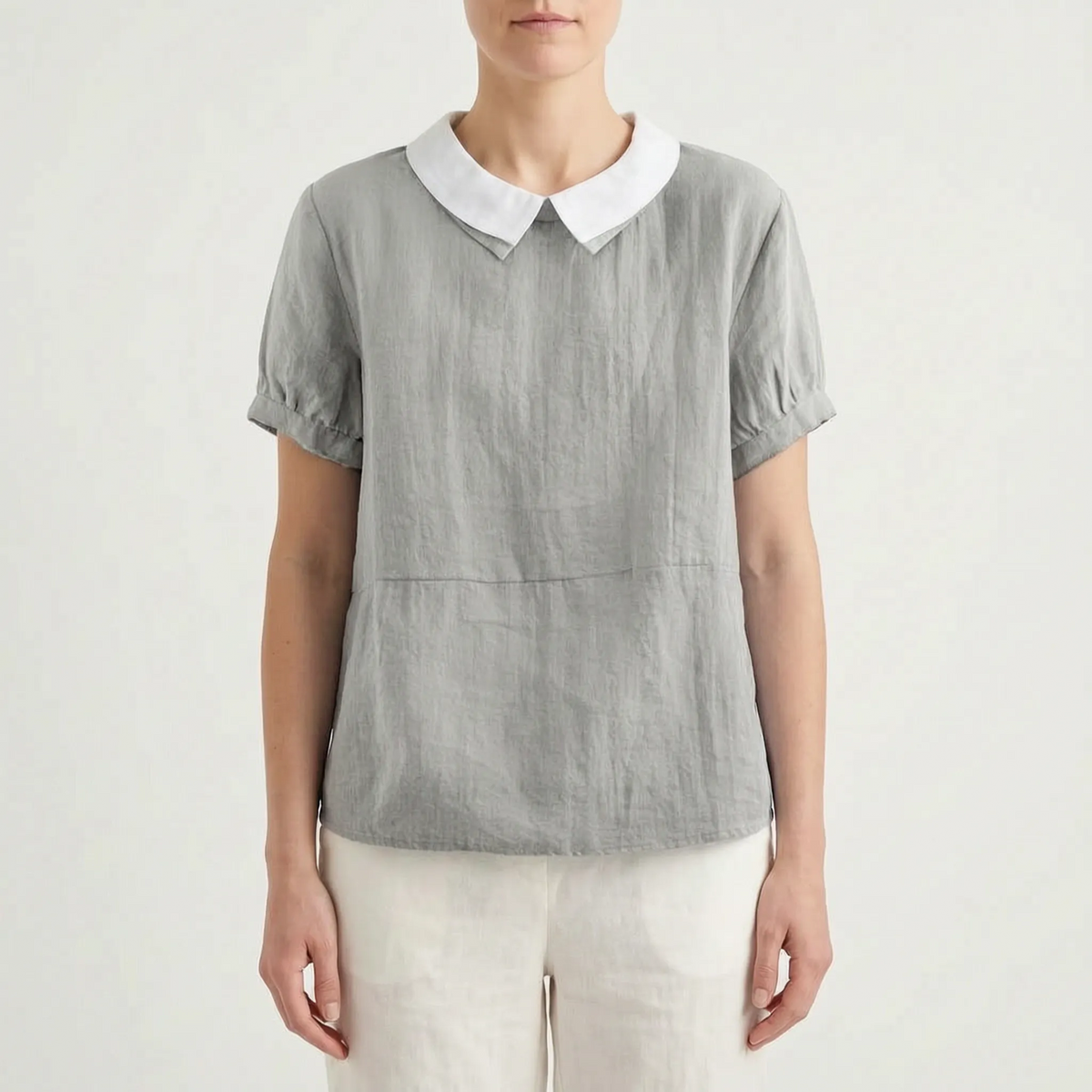 Women's light blue short-sleeved blouse with contrasting white rounded collar and curved hem