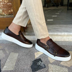 Men's double monk strap slip-on loafers shown in black and brown with white soles