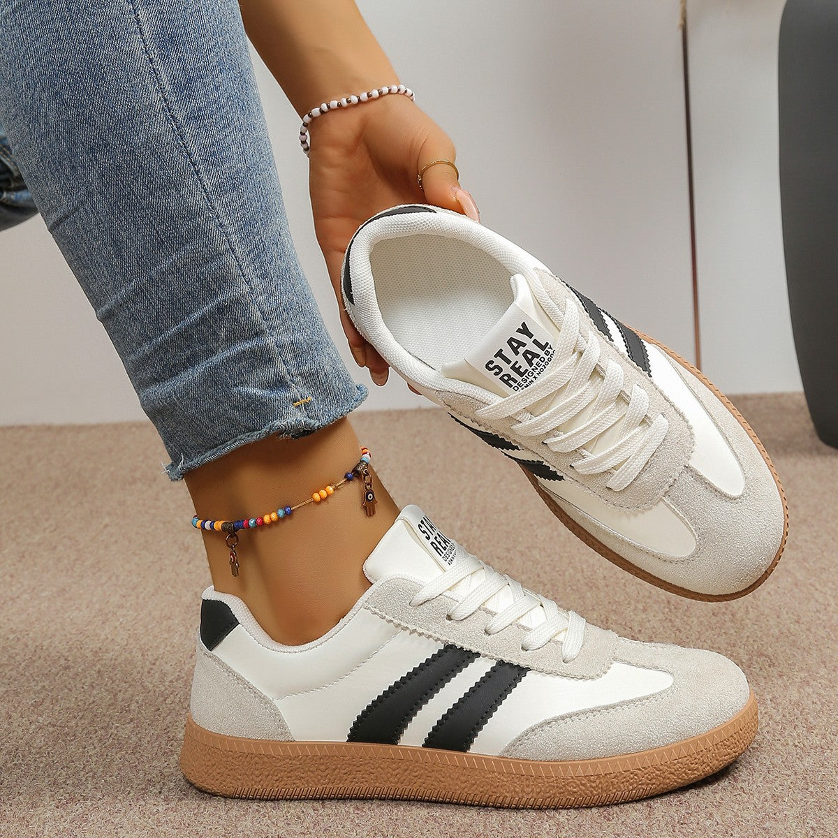 Women's low-top lace-up trainers with contrast side stripes and flat gum-coloured soles