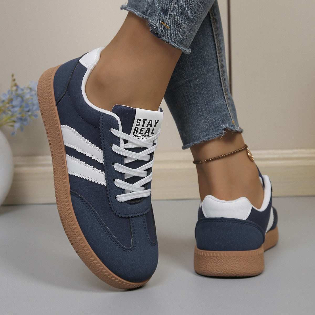 Women's low-top lace-up trainers with contrast side stripes and flat gum-coloured soles