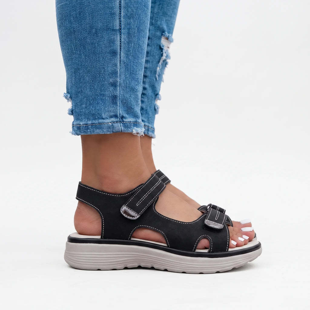 Women's black open-toe sandals with two adjustable buckled straps and raised textured soles