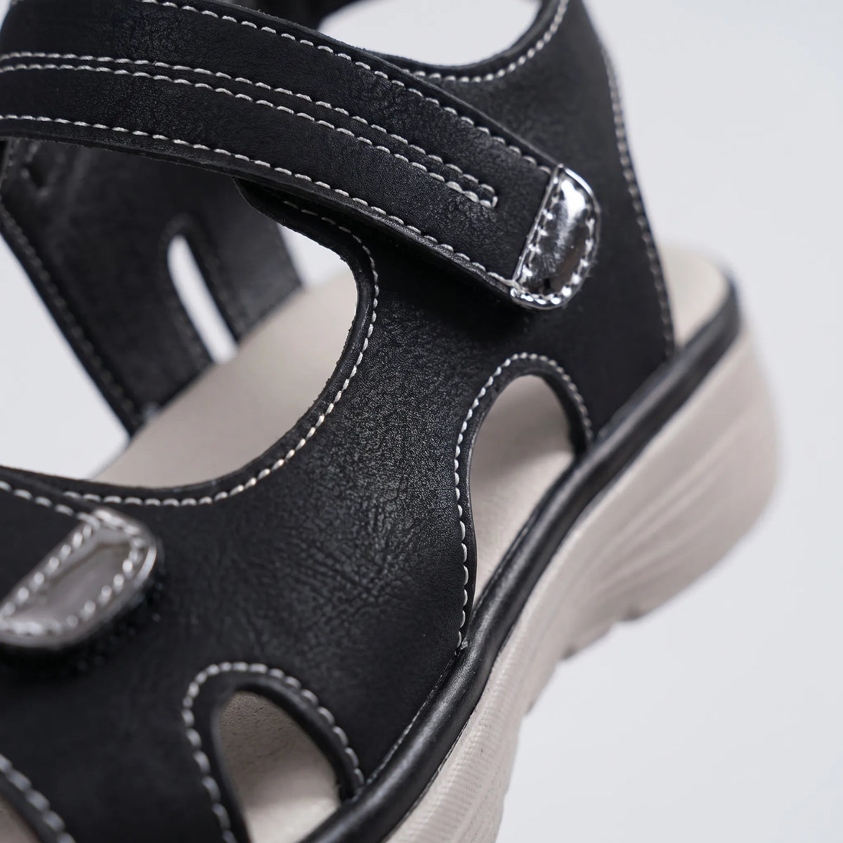 Women's black open-toe sandals with two adjustable buckled straps and raised textured soles