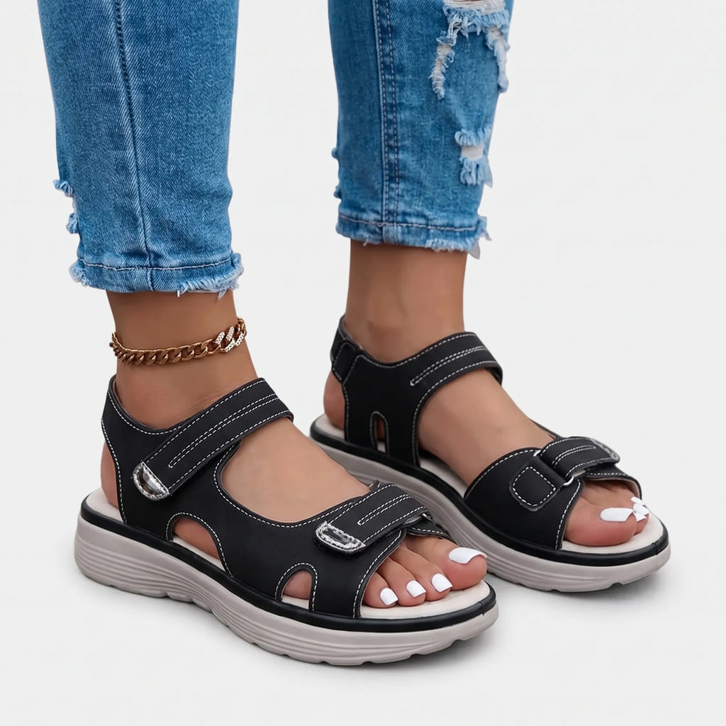 Women's black open-toe sandals with two adjustable buckled straps and raised textured soles