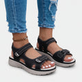 Women's black open-toe sandals with two adjustable buckled straps and raised textured soles