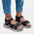 Women's black open-toe sandals with two adjustable buckled straps and raised textured soles