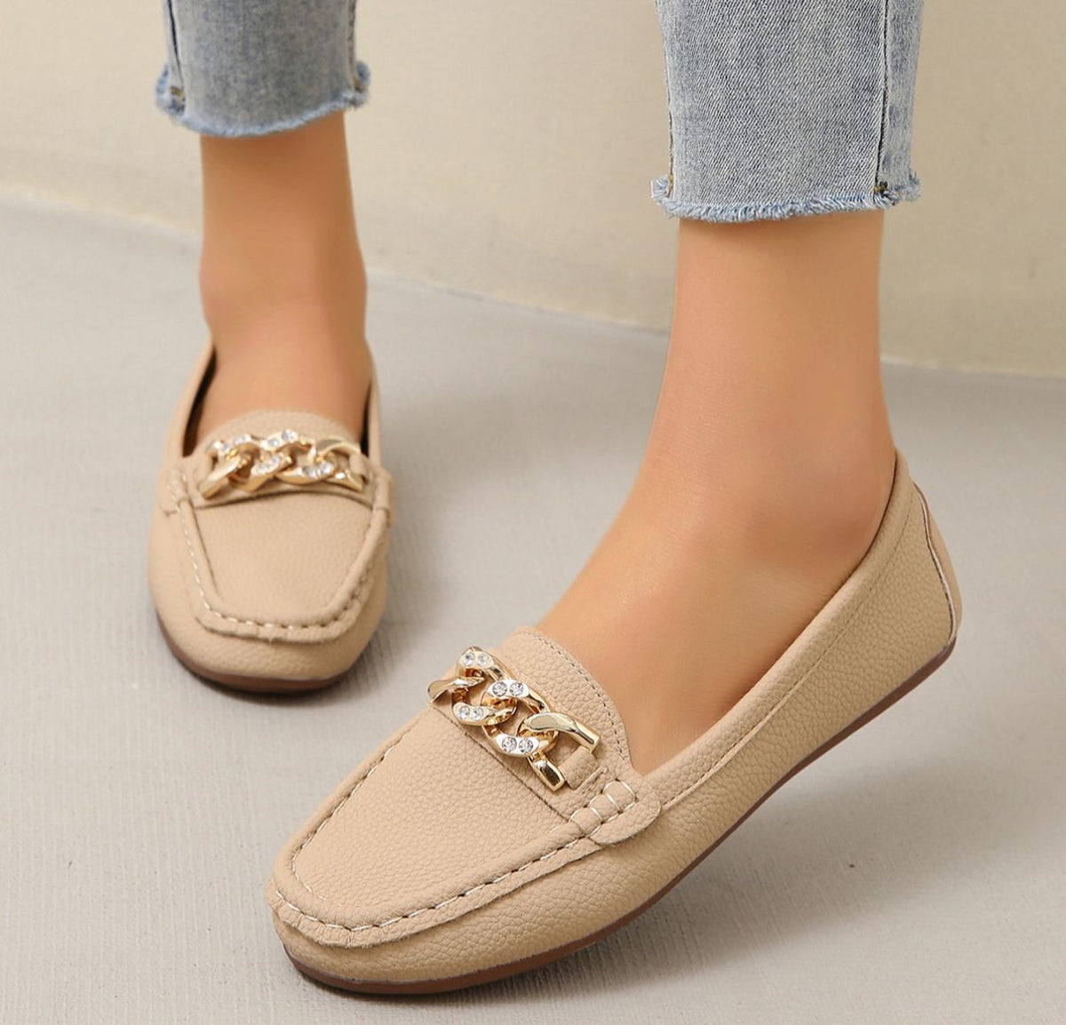 Women's flat slip-on loafers with moc toe stitching and decorative chain detail