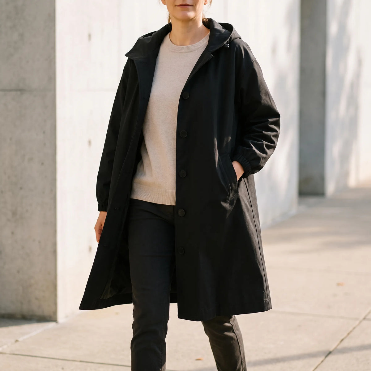 Women's long hooded waterproof coat with button front and pockets