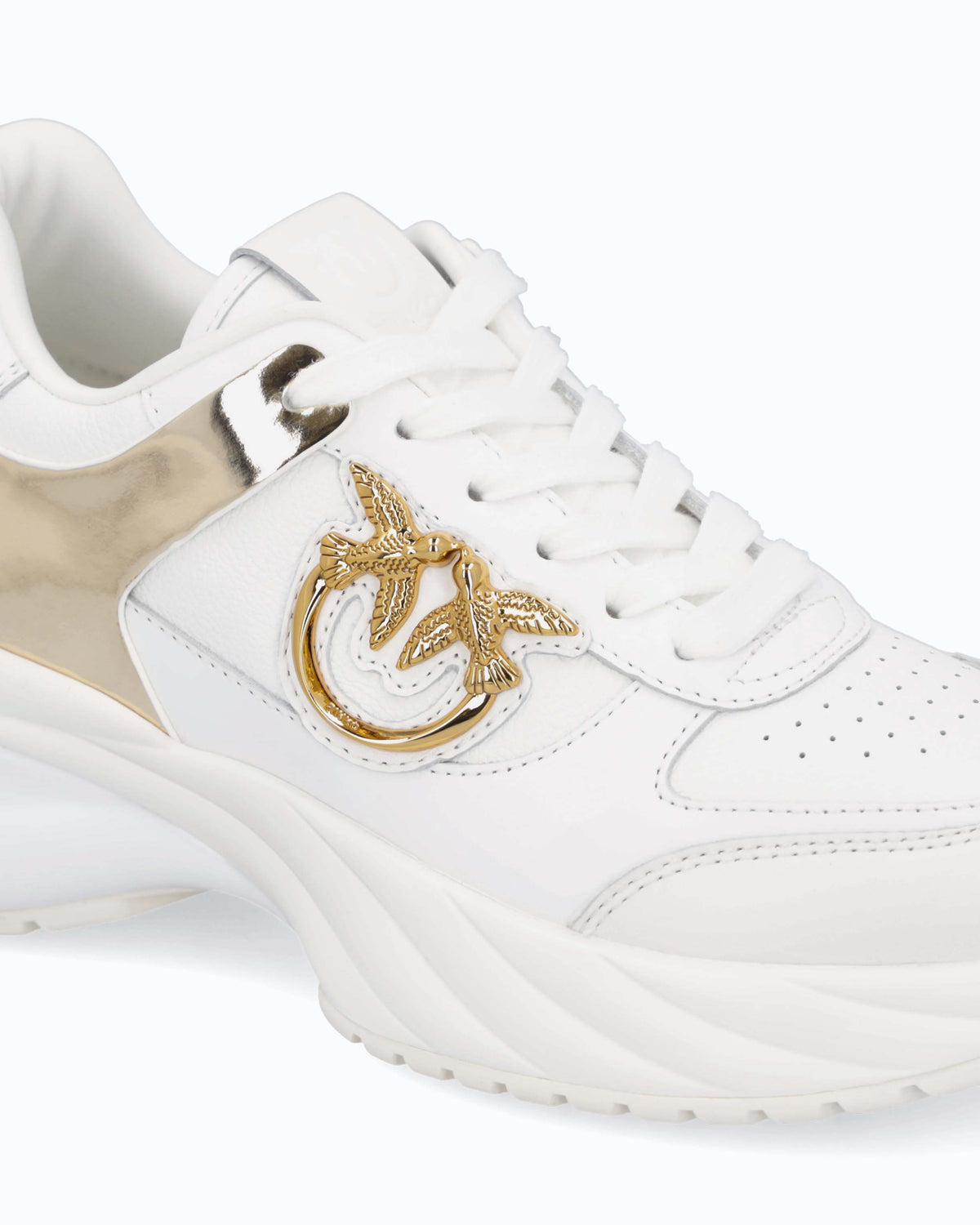 White women's trainers with gold mirror-effect side panels and chunky sole