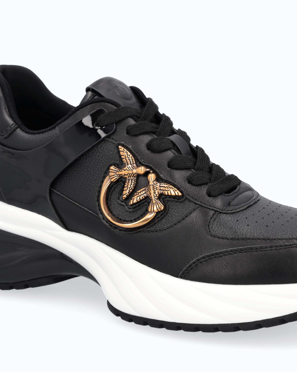 Black lace-up platform trainers with white sole and gold side emblem