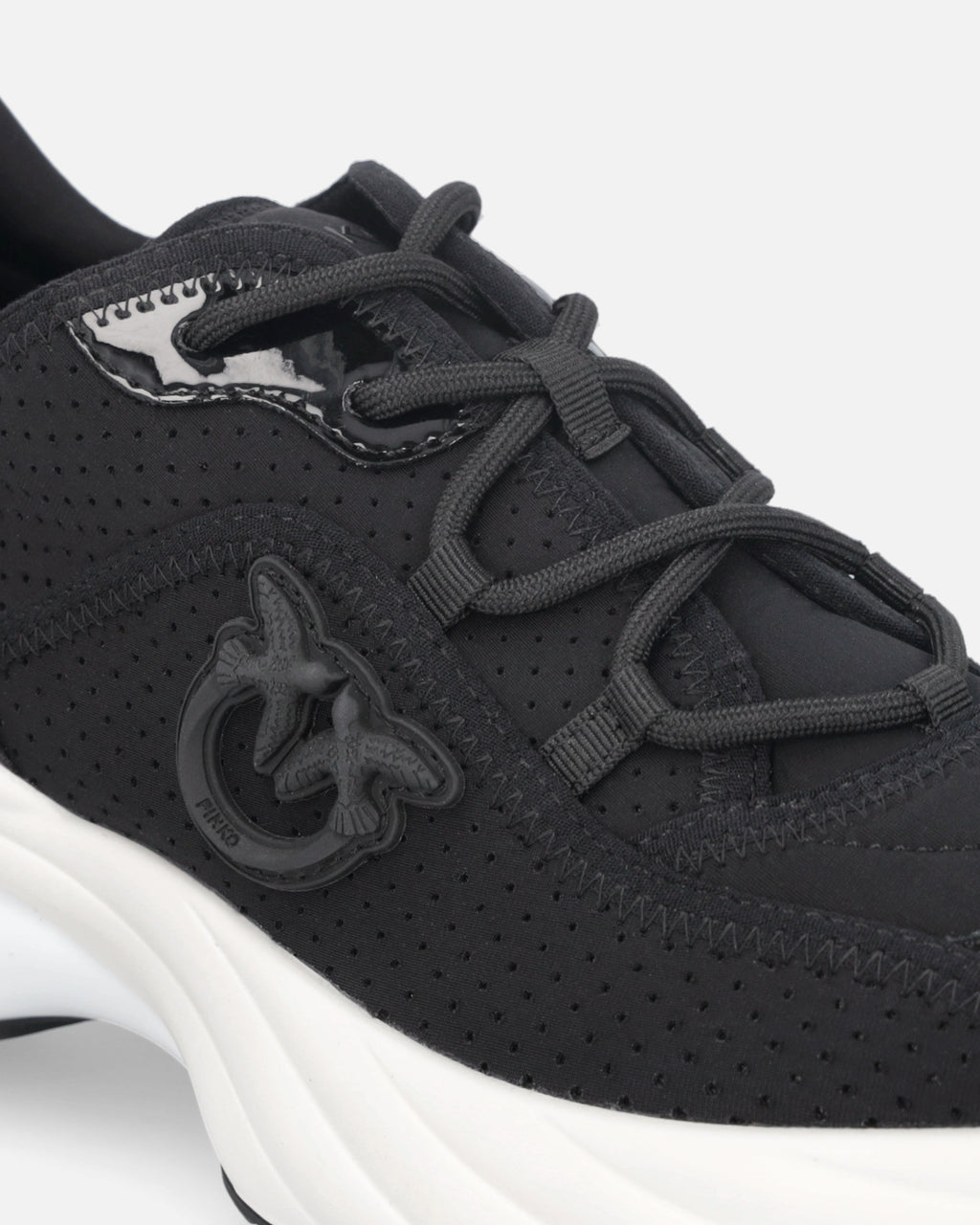 Black perforated trainers with lace-up fastening and white chunky sole