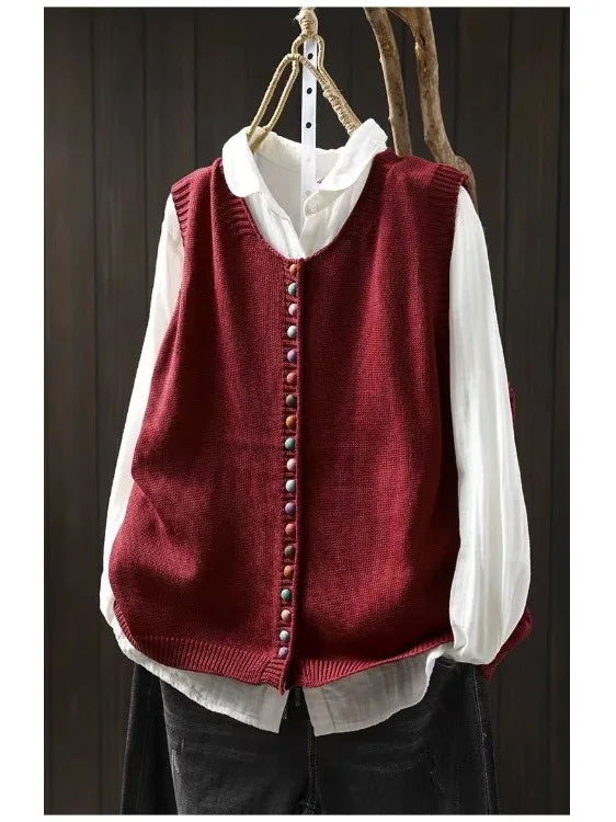 Women's sleeveless button-front cardigan vest with multicoloured buttons over a white blouse