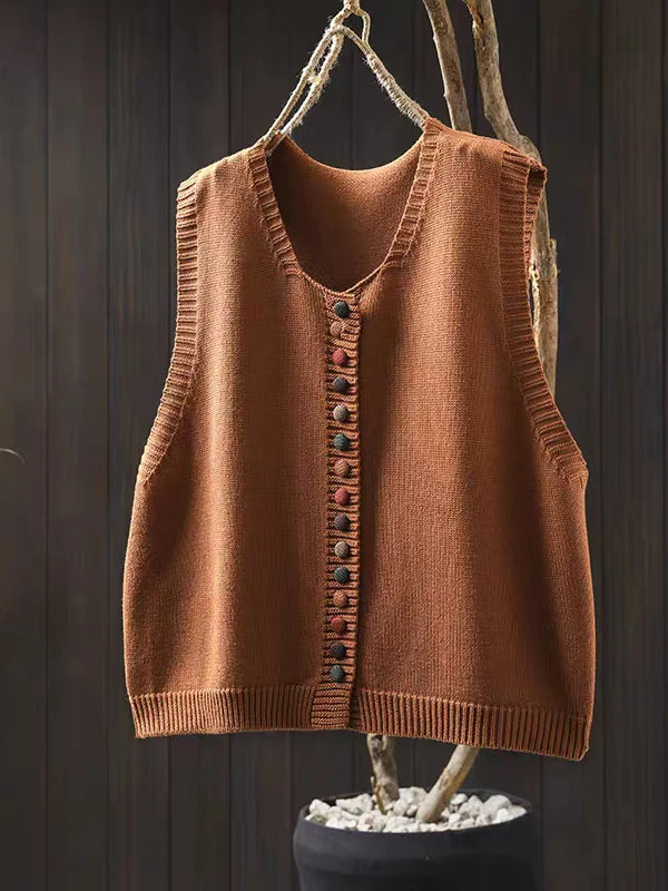 Women's sleeveless button-front cardigan vest with multicoloured buttons over a white blouse