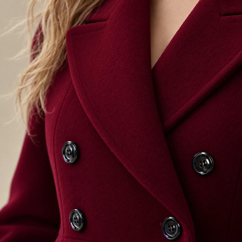 Women's burgundy double-breasted tailored long coat with notch lapels and flap pockets