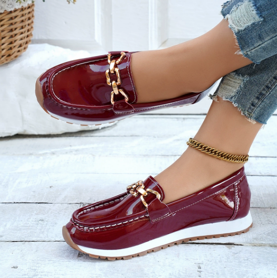 Women's burgundy patent loafers with gold chain detail and white soles