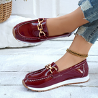 Women's burgundy patent loafers with gold chain detail and white soles