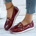 Women's burgundy patent loafers with gold chain detail and white soles