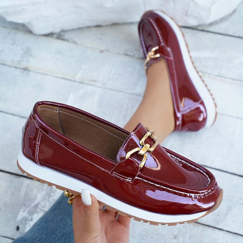 Women's burgundy patent loafers with gold chain detail and white soles