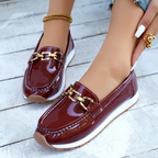 Women's burgundy patent loafers with gold chain detail and white soles