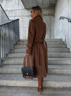 Women's long belted double-breasted coat with notched lapels and flap pockets
