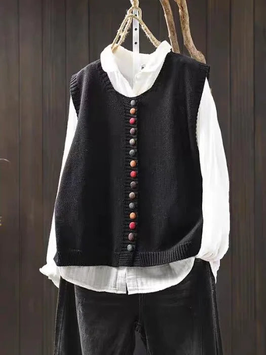 Women's sleeveless button-front cardigan vest with multicoloured buttons over a white blouse