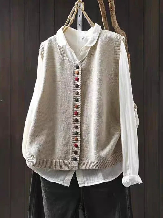 Women's sleeveless button-front cardigan vest with multicoloured buttons over a white blouse