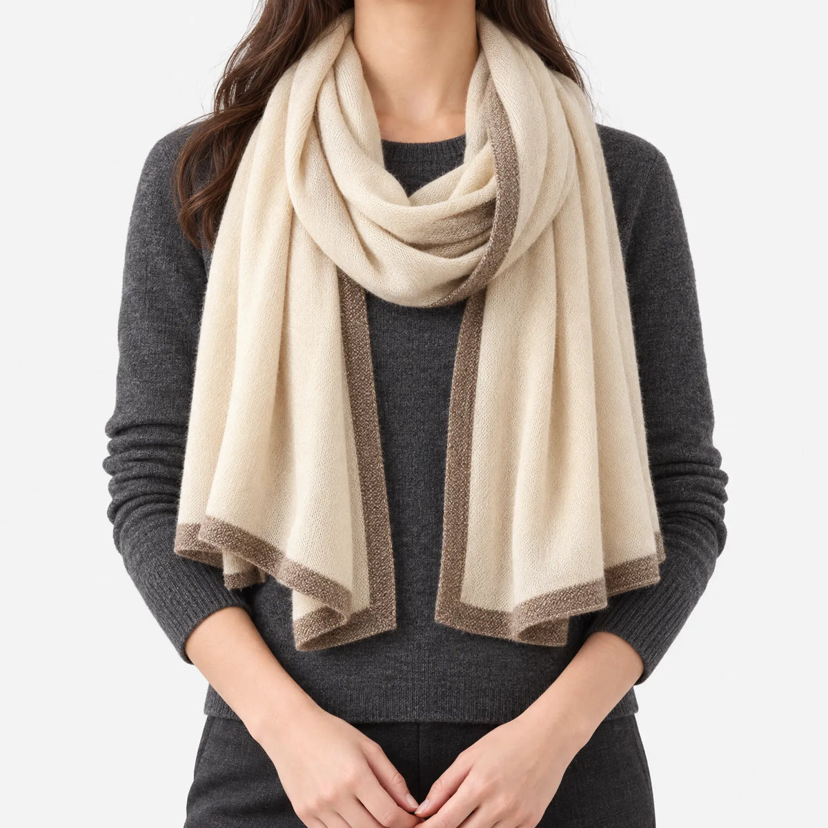 Women's cream knitted shawl scarf with contrasting border draped around the neck