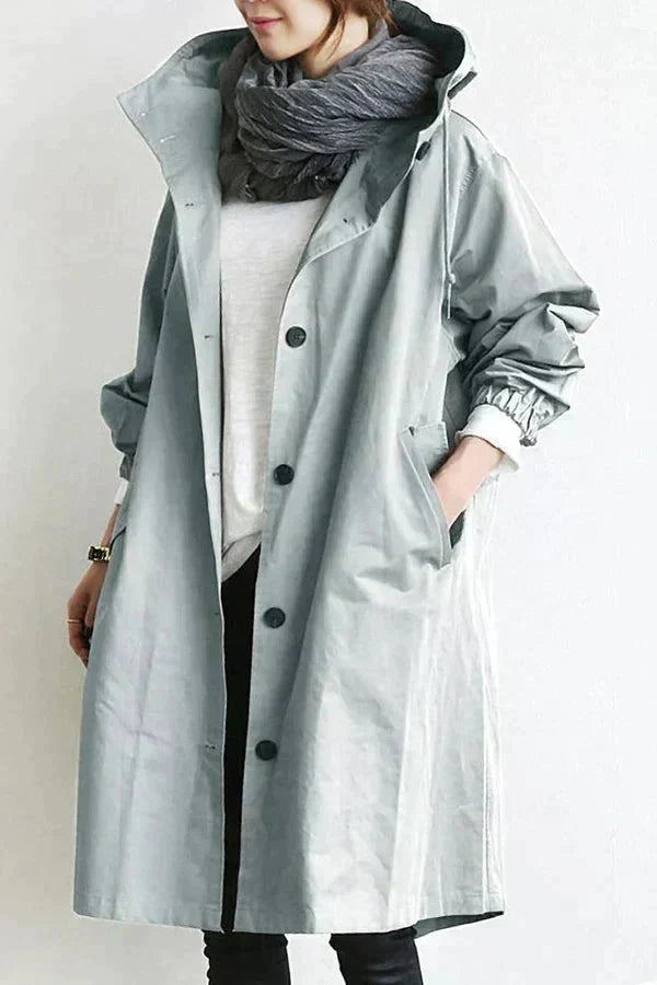 Women's long hooded raincoat with button front, side pockets and elasticated cuffs