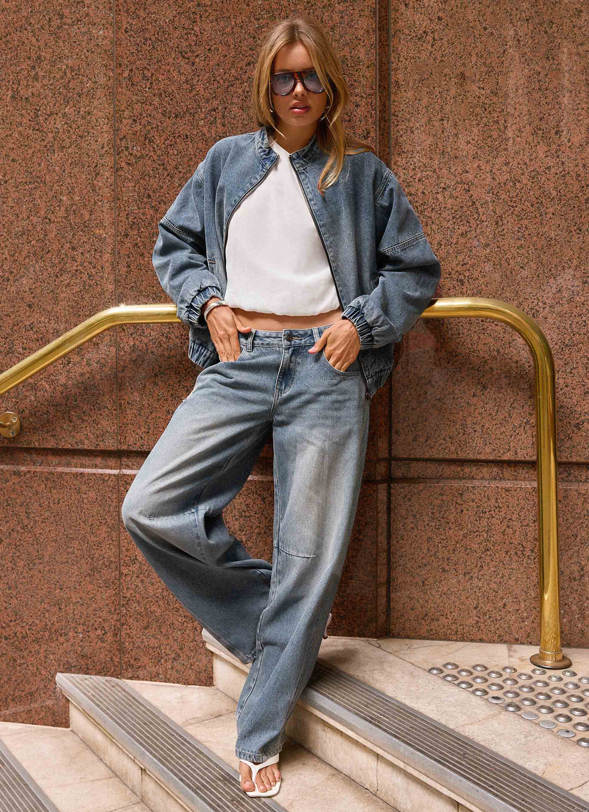 Women's blue denim bomber jacket with high collar and zip front
