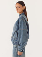 Women's blue denim bomber jacket with high collar and zip front