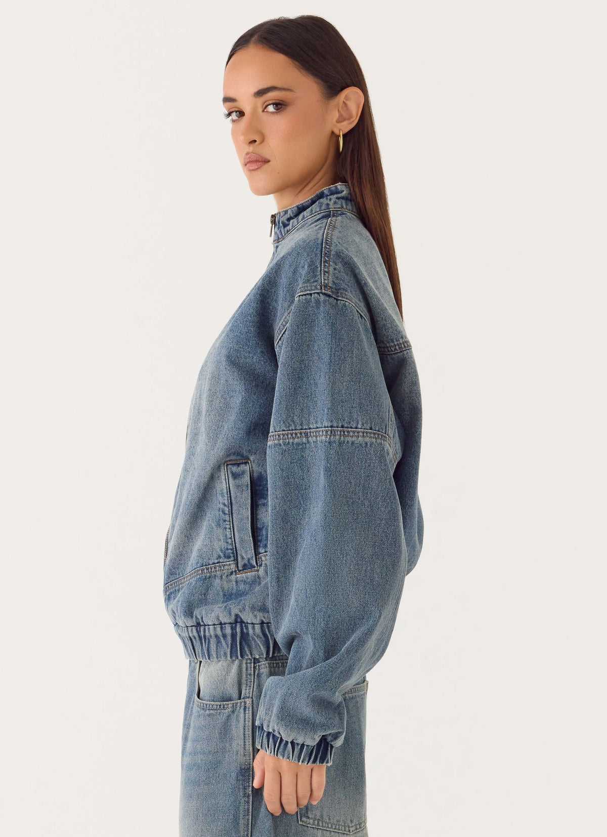 Women's blue denim bomber jacket with high collar and zip front