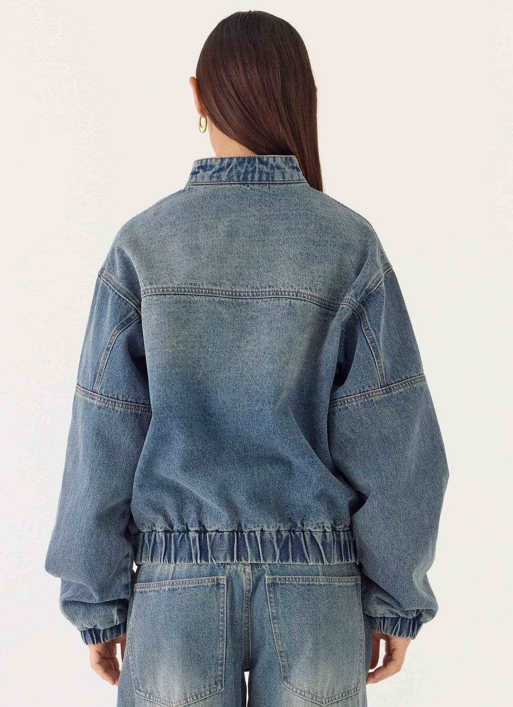 Women's blue denim bomber jacket with high collar and zip front