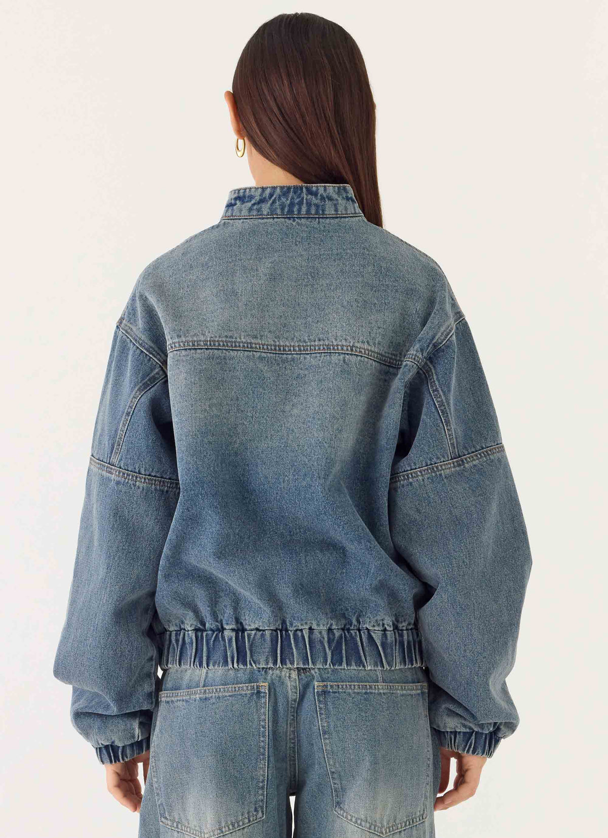 Women's blue denim bomber jacket with high collar and zip front